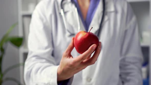 Medical Doctor Holding An Apple. Nutrociologist Nutritionist Holds An Apple. Doctor's Hands Hold