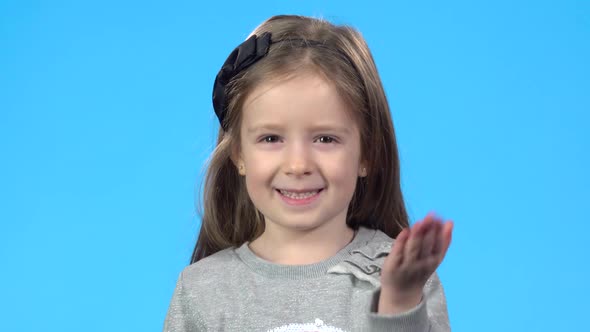 Girl Smiling, Waving Her Hand Saying Hello and Calling Someone.