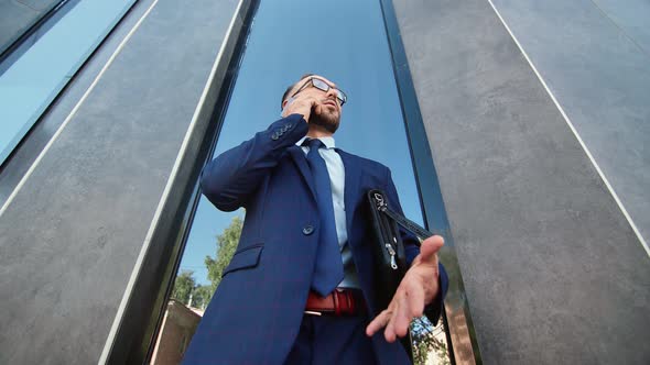 Successful Businessman in Suit Talking Smartphone at Downtown