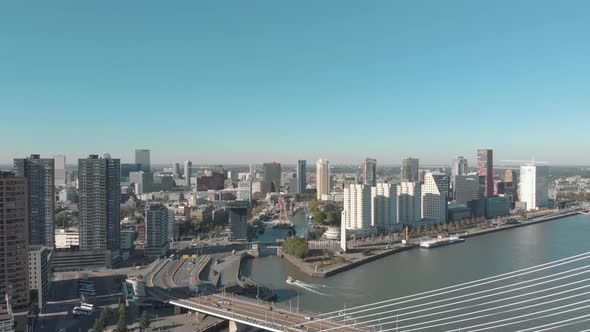 Drone footage of a slow right pan of the city of Rotterdam and it's water channel on a sunny day