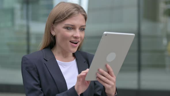 Young Businesswoman Celebrating on Tablet While Walking on the Street