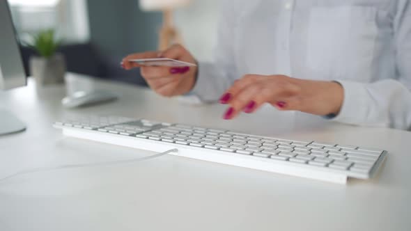 Woman Typing Credit Card Number on Computer Keyboard