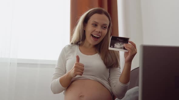 Pregnant Fairskinned Woman Shows the Interlocutor a Photo From the Ultrasound Examination of the