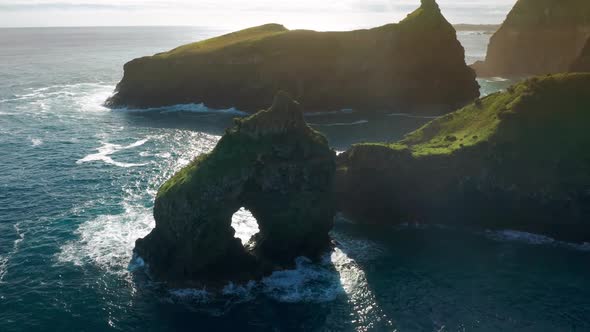 A Rock with an Arque Between Giant Cliffs and the Wild Atlantic