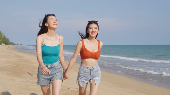 Asian young beautiful woman friends walking on the beach during summer.