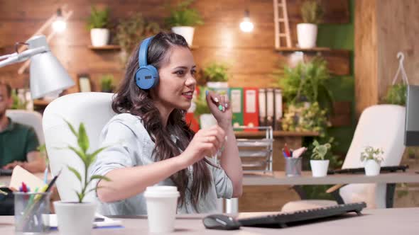 Woman Listens Music, Dances and Starts Singing at the Office