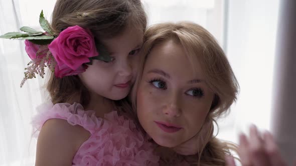 Backstage the Photographer with Beautiful Family Mother and Daughter in Pink Dress Near Large Window