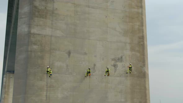 Safety Inspectors Working at Height on a Concrete Bridge Checking for Cracks