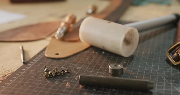 Close up of diverse tools lying on table in leather workshop