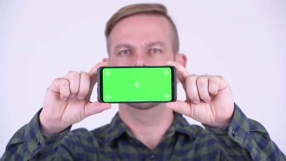 Portrait of Happy Blonde Hipster Man Showing Phone