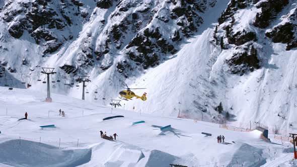 Rescue Helicopter Landing on the Slopes Helping Skier in a Ski Park