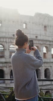 A Woman Takes Photographs of Sights of Rome on a Mobile Phone Near the Coliseum