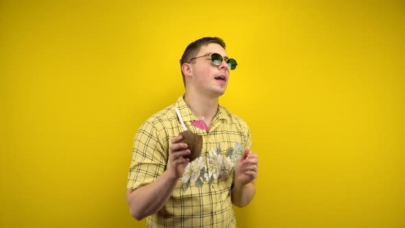 A Man in Sunglasses and a Hawaiian Shirt Is Dancing with a Coconut Pina Colada in His Hand. Shooting