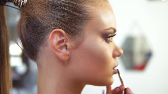 Closeup View of the Professional Makeup Artist Applying Lipstick Using Special Painting Brush to a