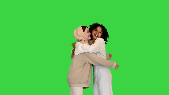 African American and a Caucasian Girl Greeting and Hugging on a Green Screen Chroma Key