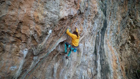 Slow Motion Back View Strong Man Rockclimber Climbs on Overhanging Limestone Crag with Colonets