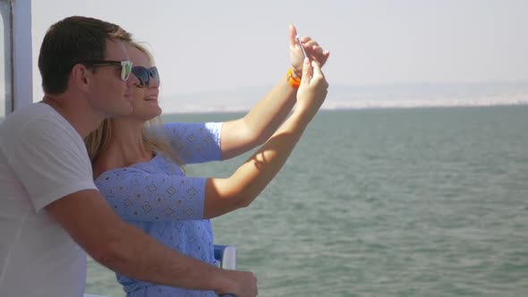 Young Couple Doing Selfie on a Mobile Phone on a Boat