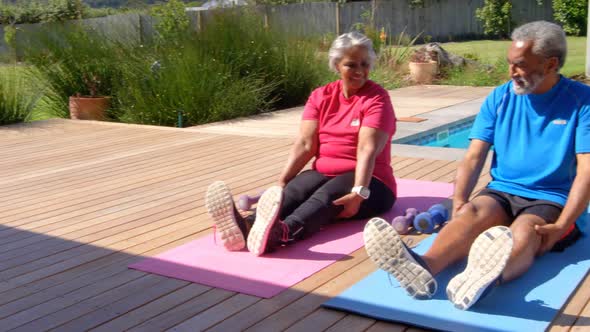 Front view of old asian senior couple exercising in the backyard of their home 4k