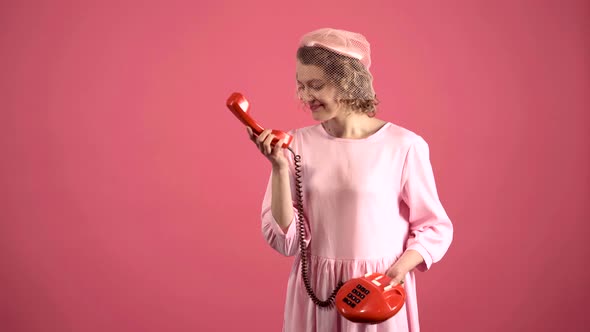 Smiling Woman Talking on Retro Telephone Isolated on Pink. Portrait of Young Pretty Woman Pinup Girl