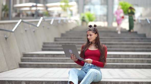 Beautiful Young Woman on the Street Using Laptop