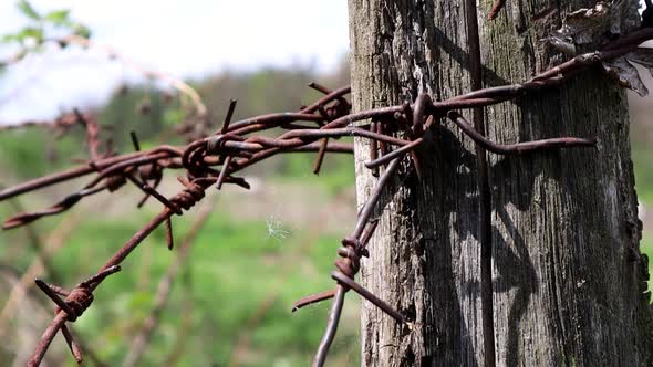 Old Wooden Fence with Rusty Barbed Wire