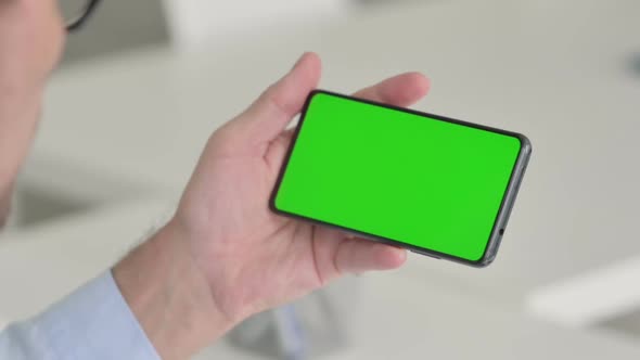 Man Holding Smartphone with Green Chroma Key Screen