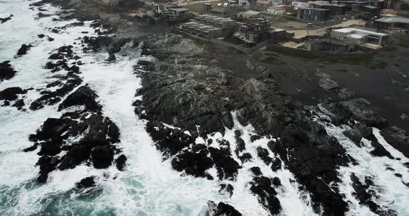 Aerial orbit of the rocks off the coast of Pichilemu with a strong swell.