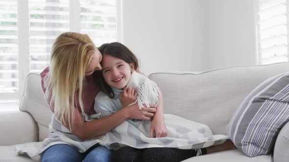 Mother embracing her daughter at home