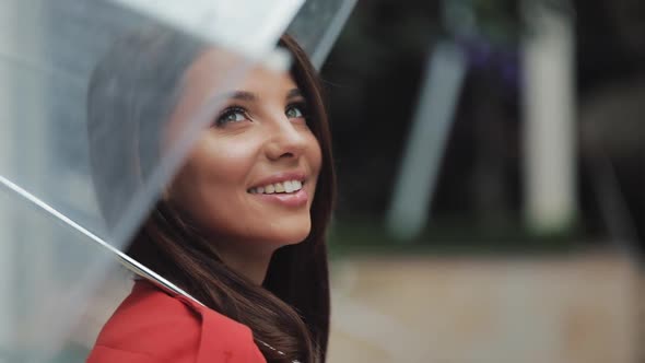 Portrait of Smiling Woman Under Umbrella in City Looking Looking Sideways