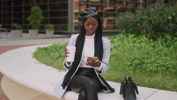 Black Woman with Smartphone Drinking Coffee