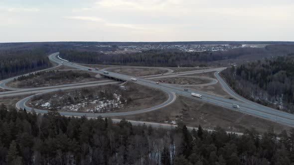 A Car Interchange with an Overpass on a Cloudy Spring Evening in the Woods