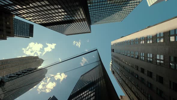 Bottom View of Pass By Several Skyscrapers in a Peaceful City Under the Cloudy Sky in Calm Day