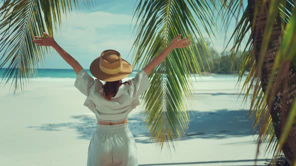 Happy woman with hat relaxing at the seaside and looking away