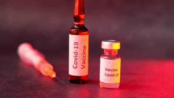 Close Up of Coronavirus Vaccine and Syringe on Black Background