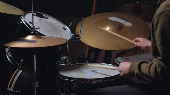 Man Sits Down To Play the Drum Set