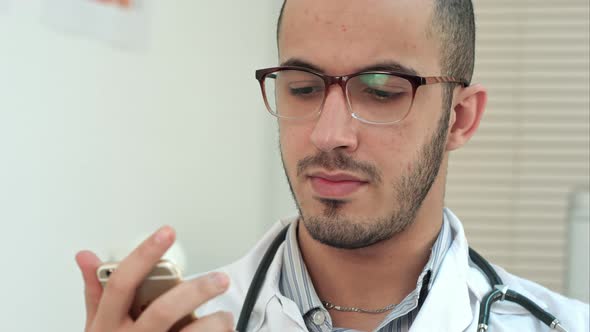 Male Doctor Texting on a Smartphone