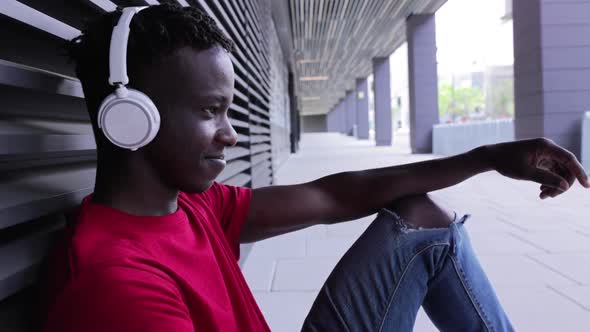 Afro American Young Man Listening to Music with Headphones on Mobile Phone