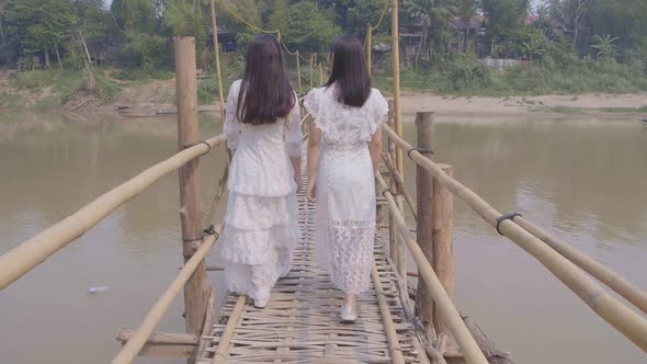 Two Girls Walking On Bamboo Bridge Cross River