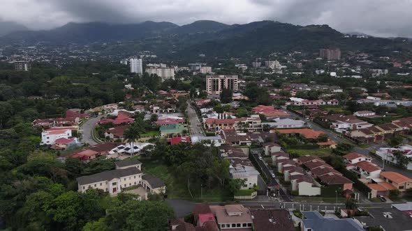 Aerial shot flying over San Jose city and Escazu mountain range, Costa Rica