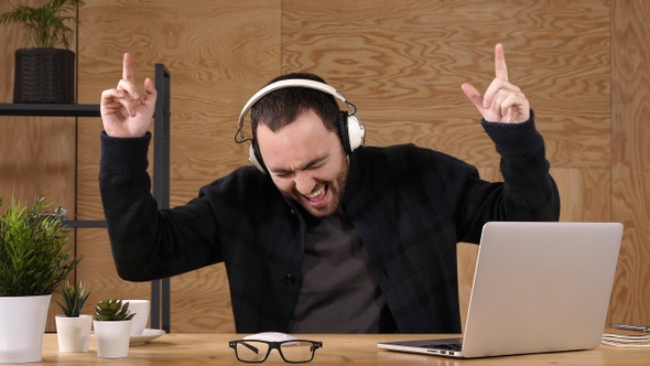 Man listening to music on headphones and singing emotionaly