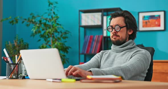 Weird Man Works in Front of Computer Writes Back Emails to Customers Taps on Laptop