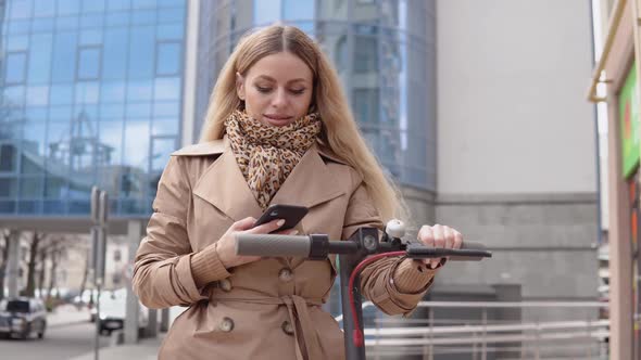 A Young Woman Rents Electric Scooter Using Mobile Phone App