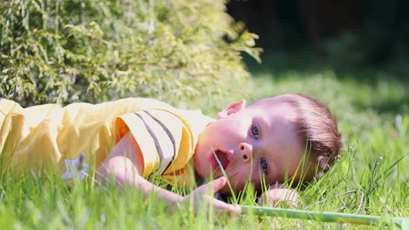 Caucasian Child Kid Boy Yellow Shirt Lying Grass Sunny Day Thinking Dreaming