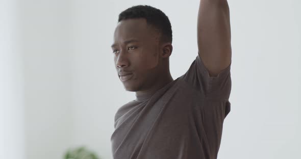 Young African American Guy Training at Home, Warming Up Hands Before Strength Workout