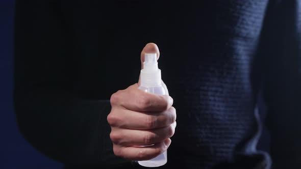 A Man Holding a Bottle Sprays a Disinfectant