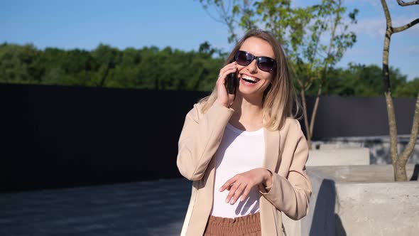 Adult Energetic Positive Young Woman Talking on Mobile Phone Outside Near Park