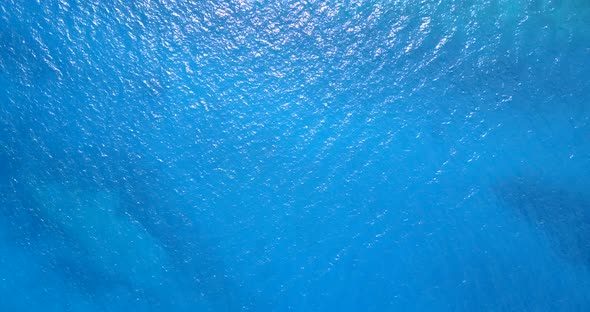 Daytime fly over abstract view of a paradise sunny white sand beach and blue water background