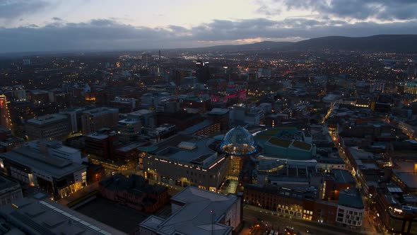 Aerial flyover of Belfast City Centre and Lagan River at night