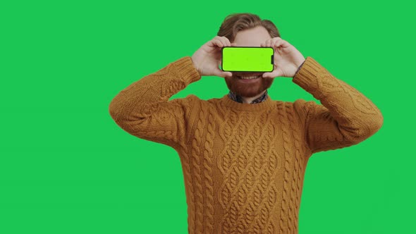 Caucasian Young Entrepreneur Holding Mockup Green Screen Smartphone in Front of His Eyes Medium