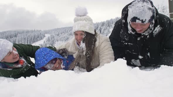 Group of Friends Cheerfully Sprinkles Snow on Each Other